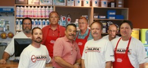 a group of men gathered around a hajoca profit center plumbing counter