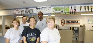 A group of 5 teammates posing in front of a sales counter