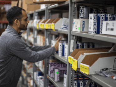 Man looking at plumbing items on a shelf.